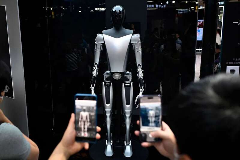 2023 世界人工智能大会，参观者在拍摄特斯拉机器人