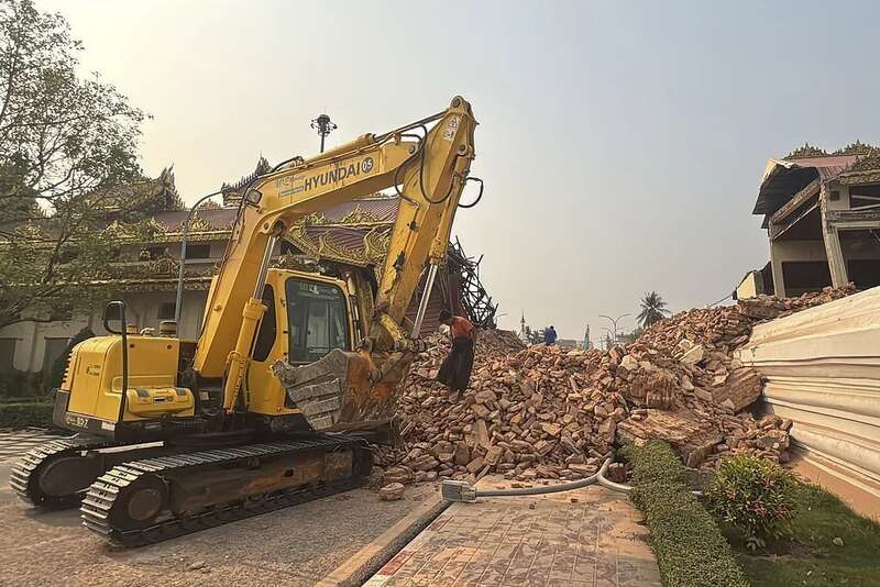 缅甸曼德勒，志愿者驾驶挖掘机在马哈木尼佛塔旁协助救援